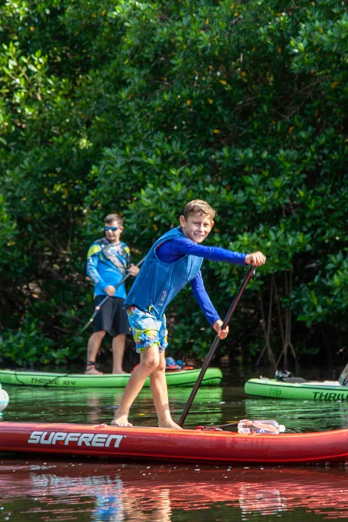 niño practicando stand up paddleboarding